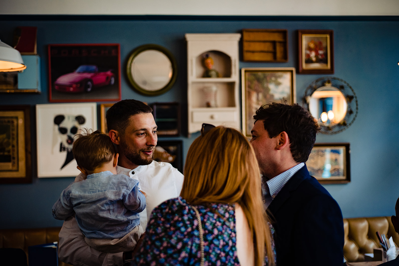 The groom holding his son and chatting with his guests.