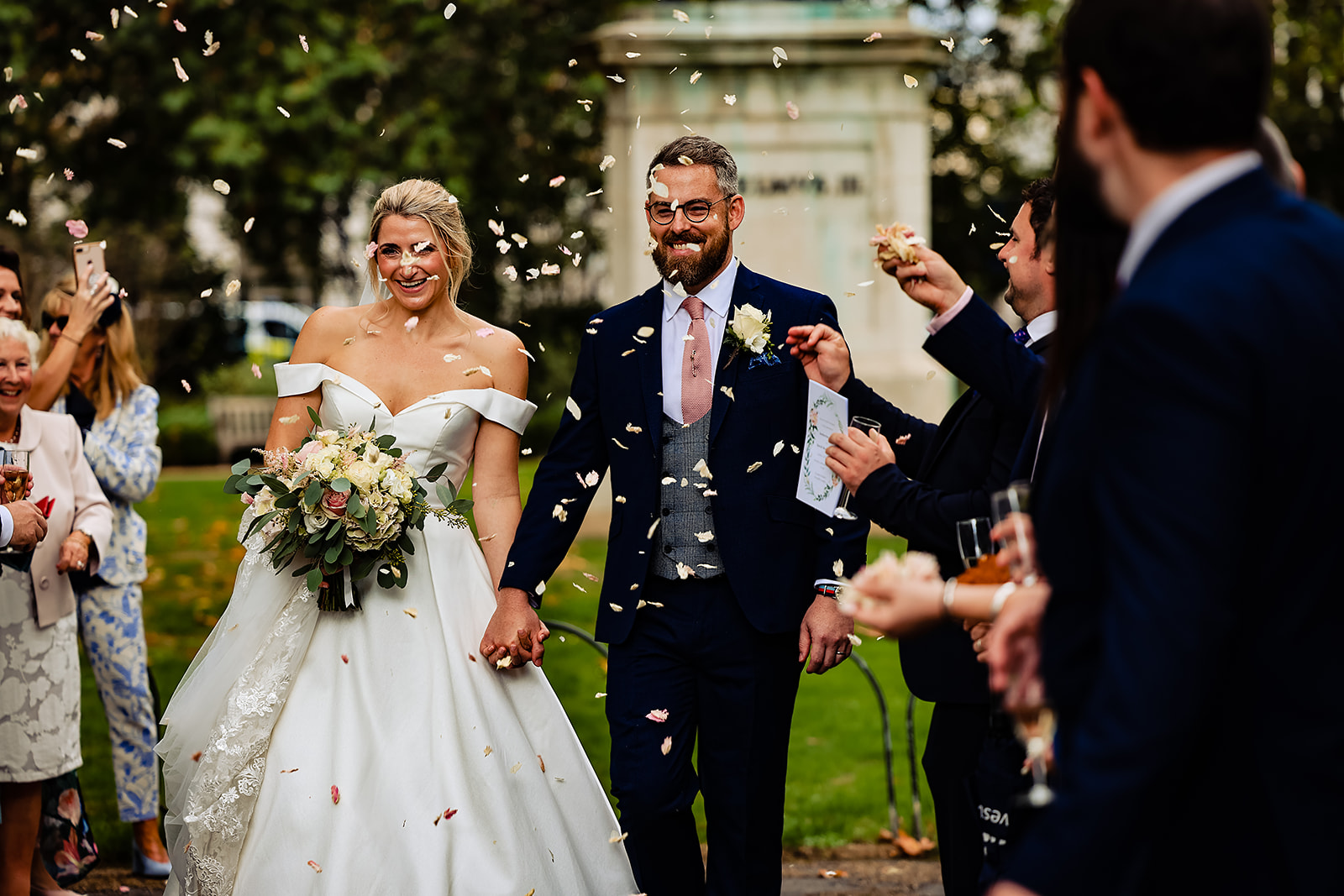 A couple being showered in dry petal confetti.