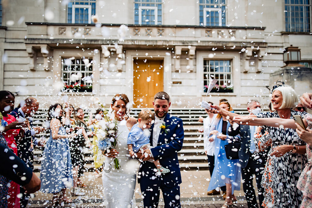 A happy couple being showered in confetti outside Hackney Town Hall 