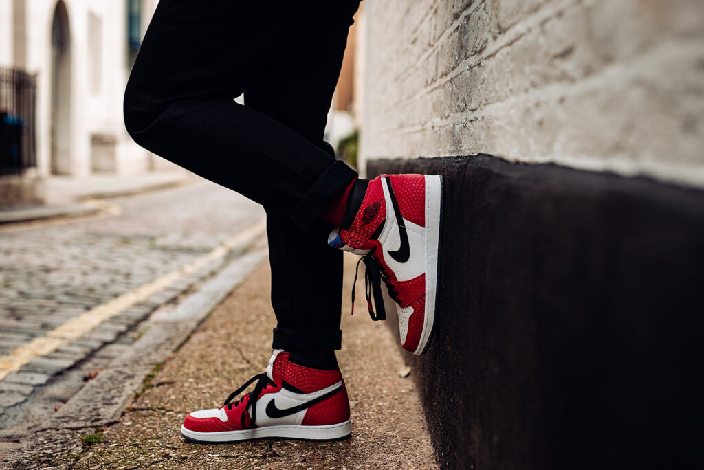 Photo shows a groom's shoes. They are red, white and black trainers, limited edition Spider Man Nike Air. 
