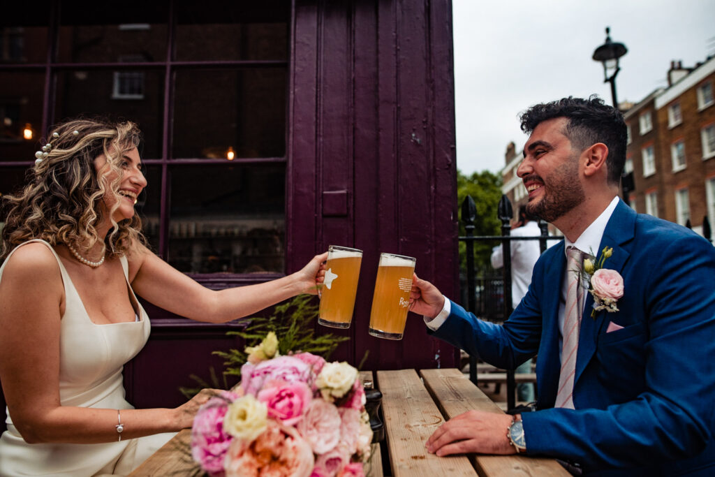 A bride and groom take a moment to get a pint at the pub during their wedding day with their wedding photographer 