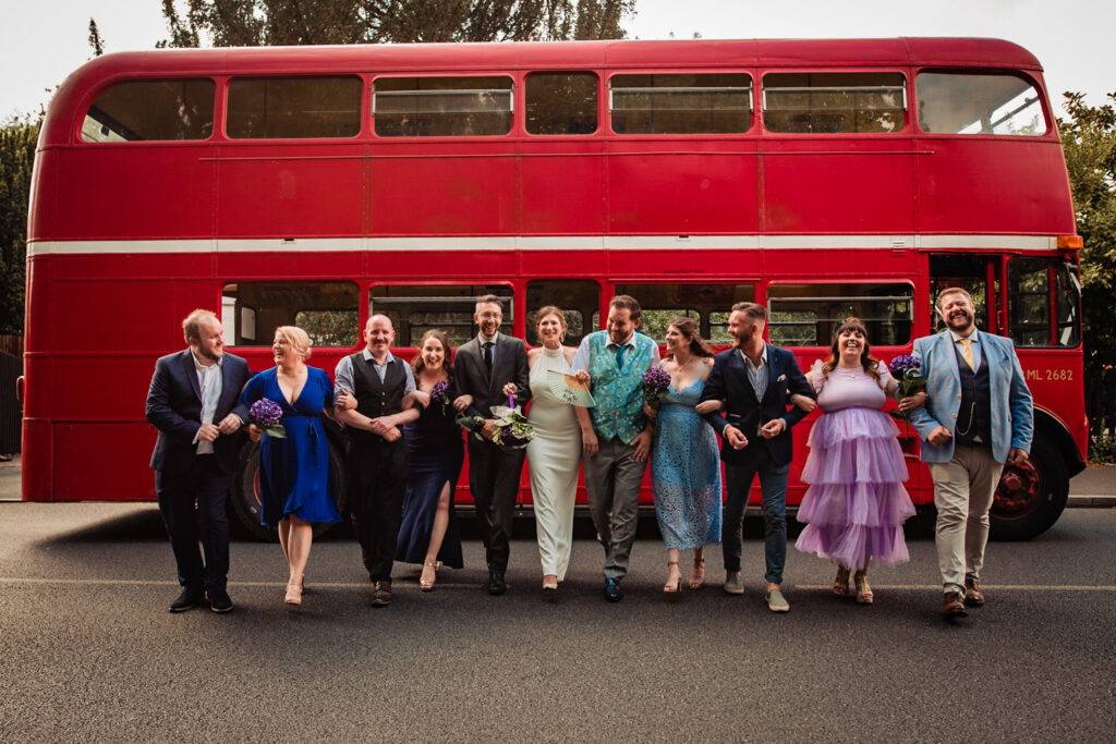 A group of wedding guests in front of a London bus, hired by the bride and groom as wedding transport.