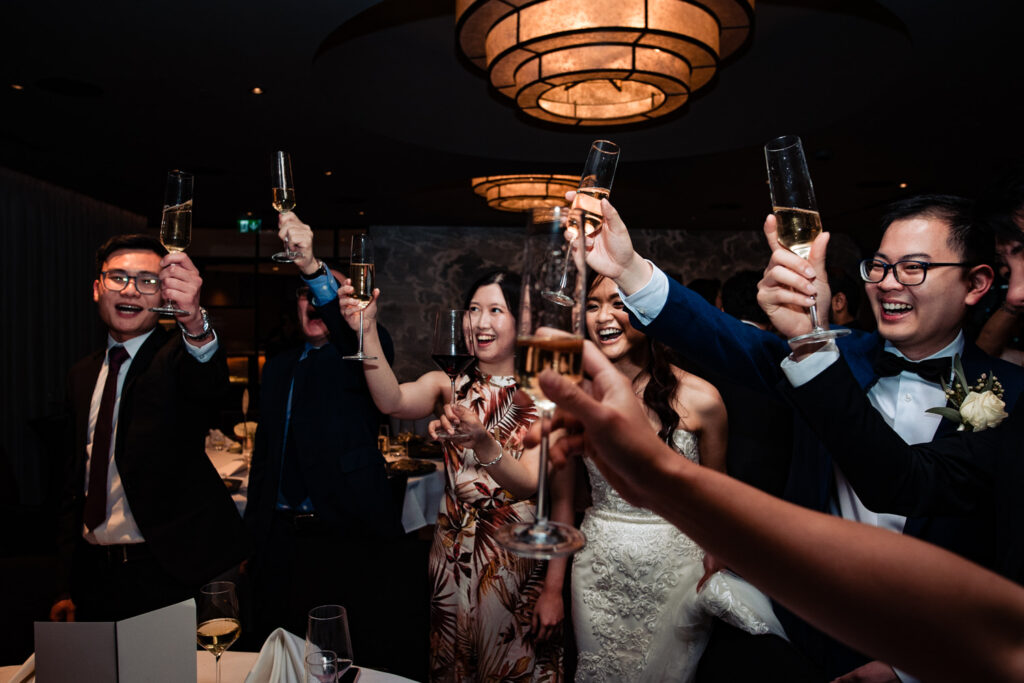 A wedding party raise their glasses in a toast