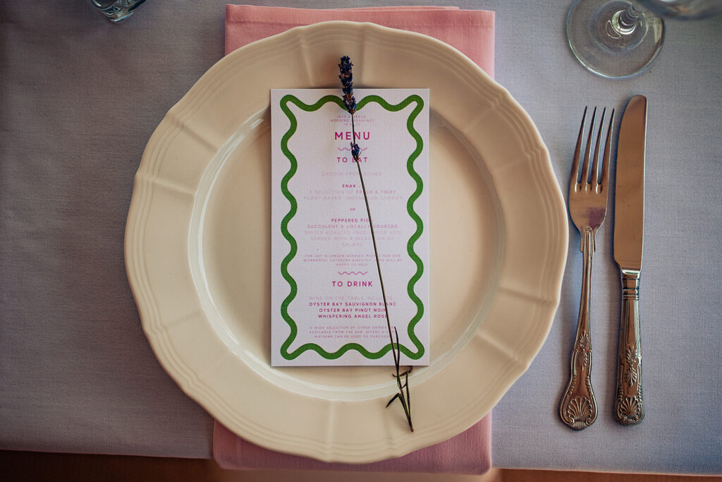 a wedding plate set with a green and white menu. 