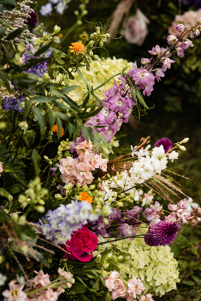 A close up of a flower arch, visible are roses and other wildflowers
