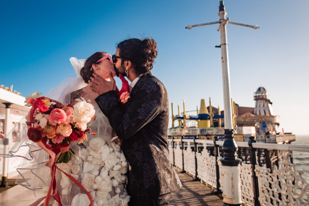 An alternative couple kiss at an elopement on Brighton Pier
