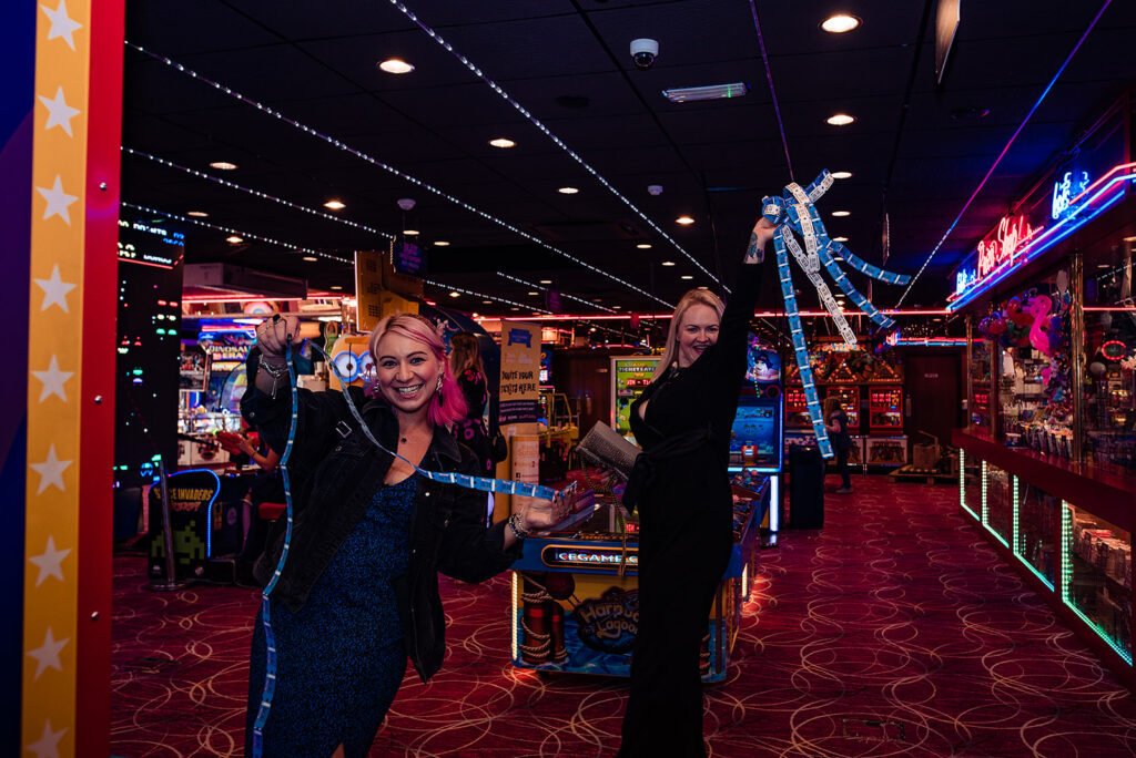 An Alternative wedding: A bride and groom rent a gaming casino by the coast for their entertainment. All the guests celebrate by playing arcade games.