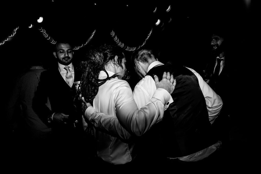 An Alternative wedding: Dancing moments from the wedding reception party of the band night. Guests have their arms around each other.