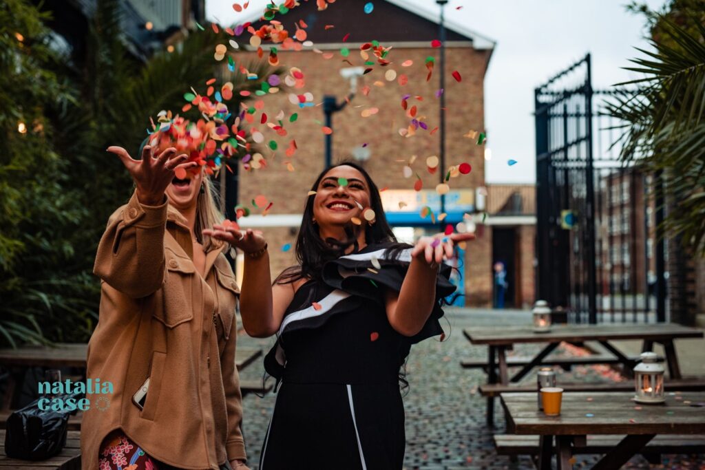 Guests throw colourful confetti at the end of a winter wedding ceremony. 