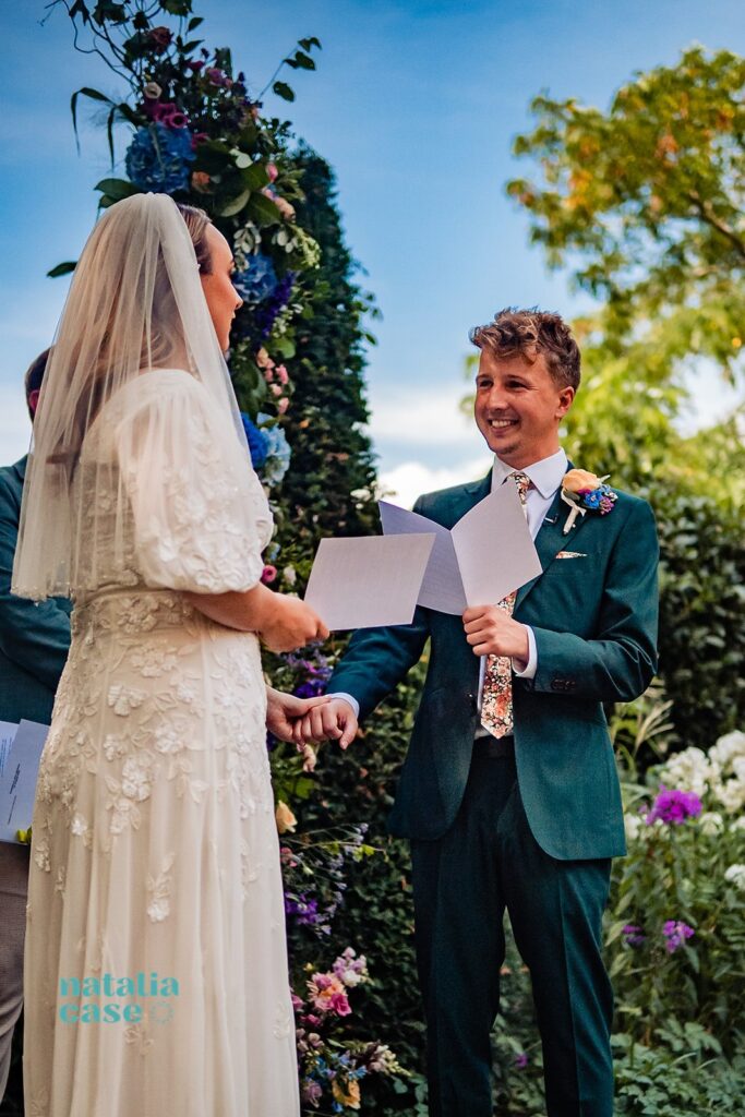 A bride and groom read their vows at an outdoor wedding ceremony at The Bingham Riverhouse, Richmond