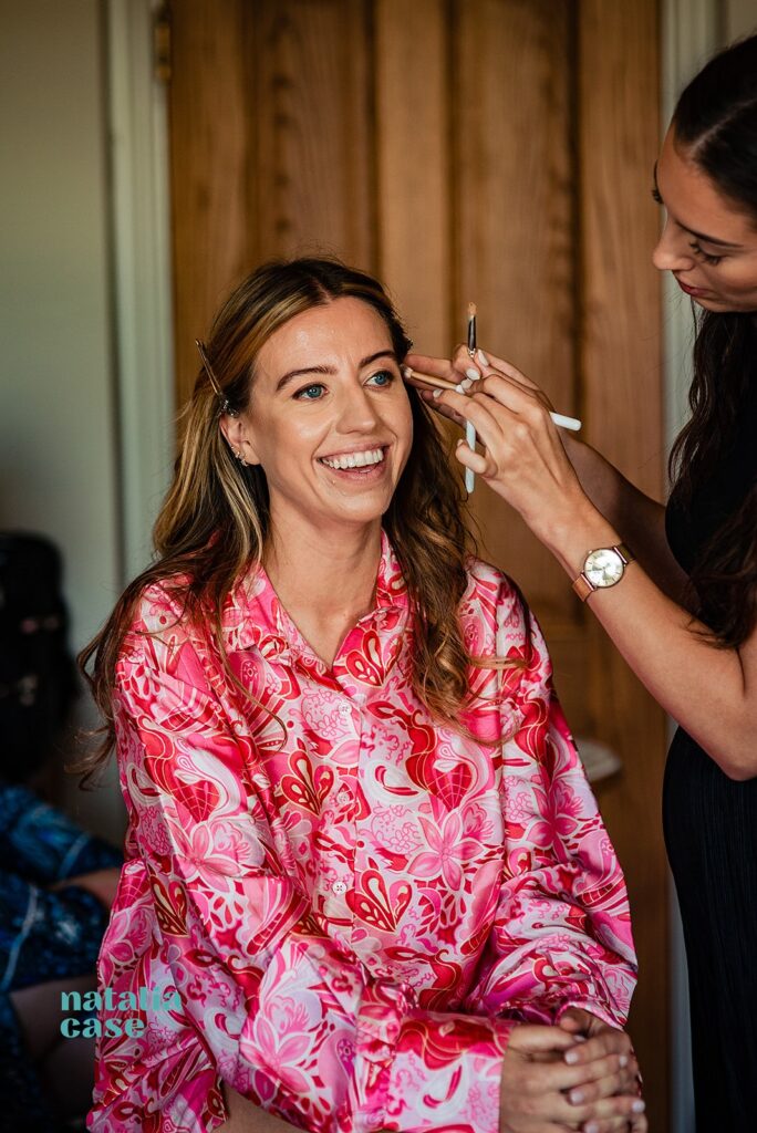 Bridesmaids get ready on the wedding morning with the help of a hair and make up stylist 