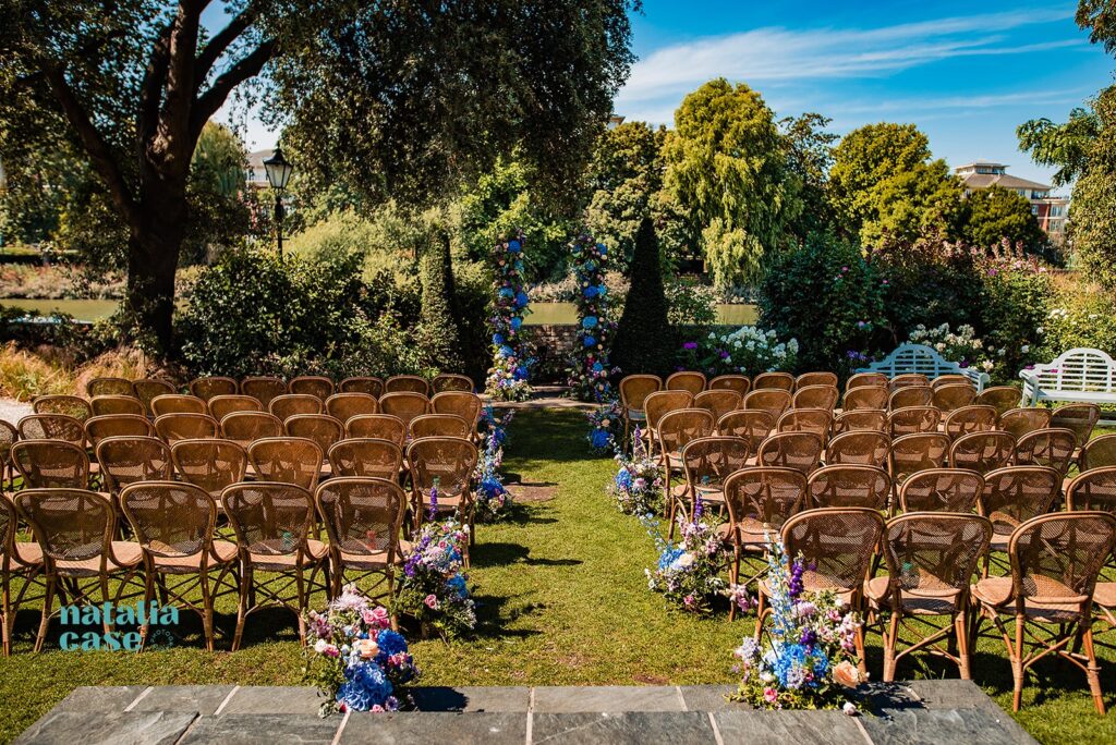 Wedding florals by Flora and Bee - aisle flowers decorating the chairs in bright summer colours, blues and pinks with dahlias at The Bingham Riverhouse, Richmond