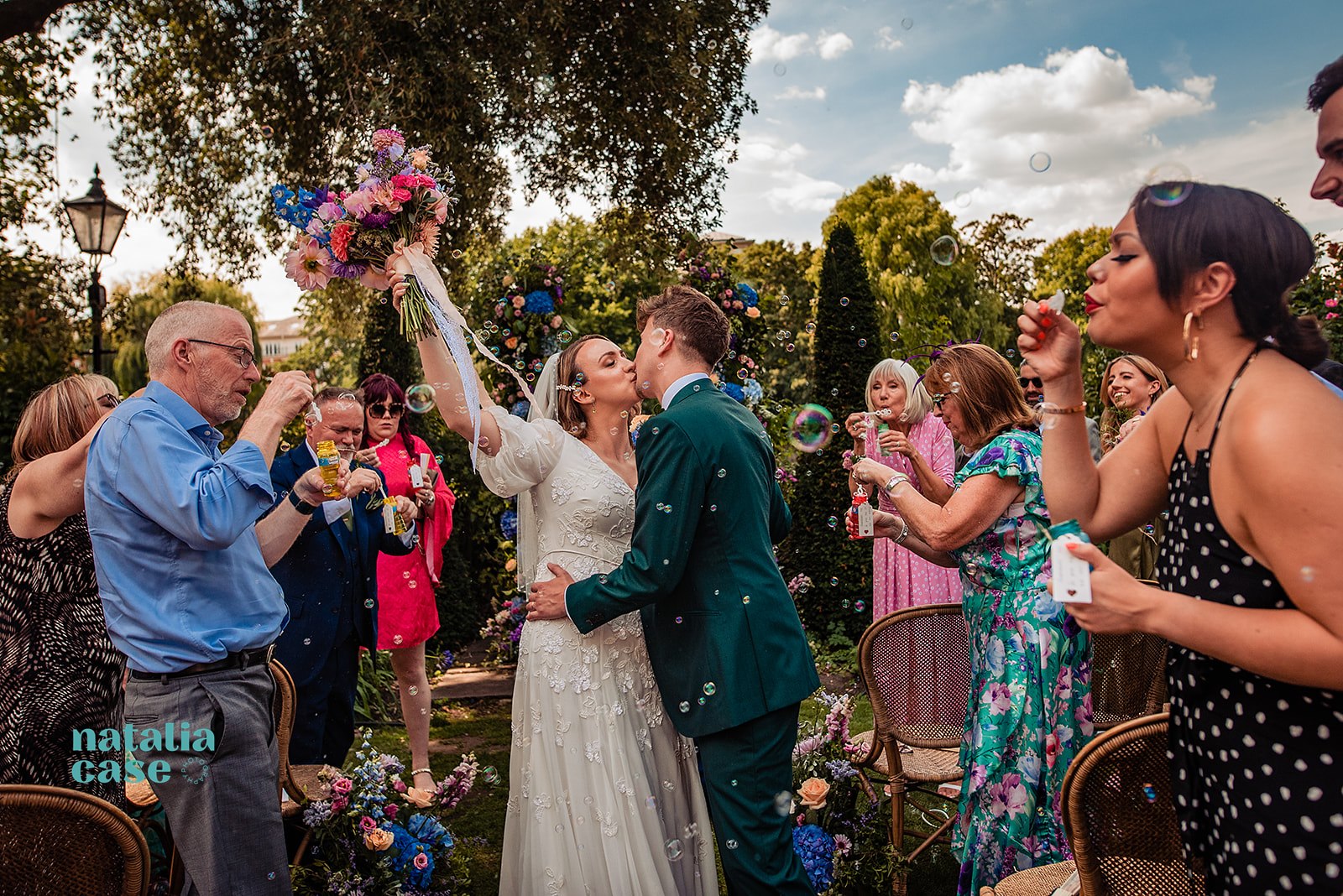 A bride and groom kiss during their Summer Wedding at The Bingham Riverhouse. The guests blow bubbles instead of throwing confetti