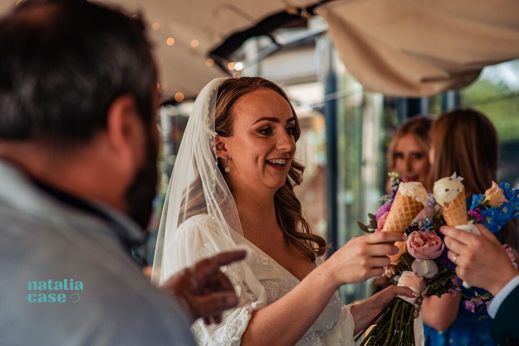 The bride holds her ice cream cone at her wedding reception