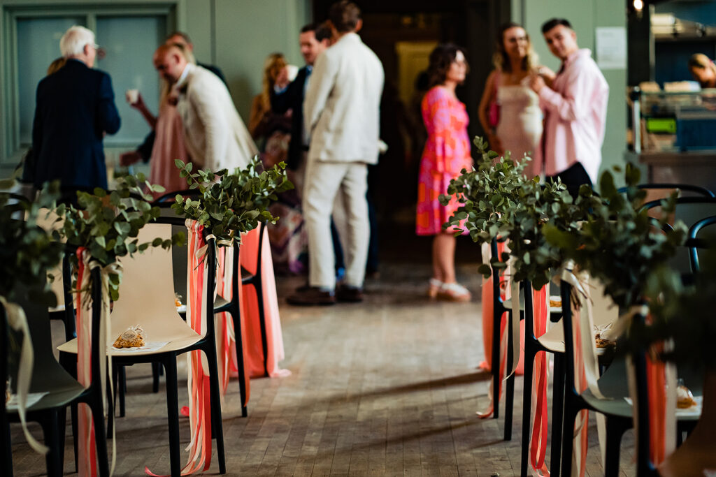 A view down the aisle. The ceremony aisle chairs have green foliage attached to them