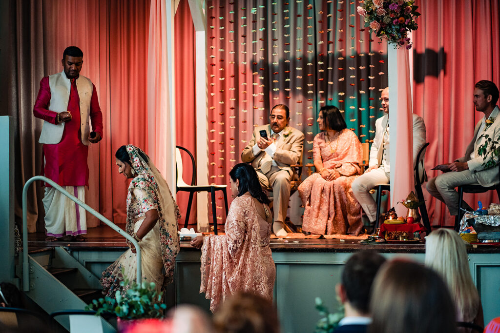 The groom waiting for his bride as she makes her way down the aisle at their Hindu ceremony