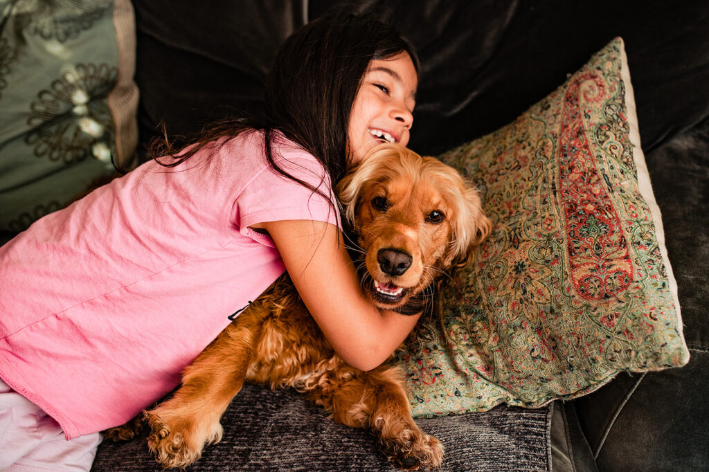 A flowergirl cuddling a happy dog