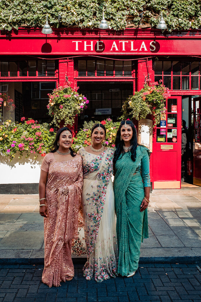 The bride and her friends and guests smiling outside The Atlas Pub on Seagrave Road, South West London