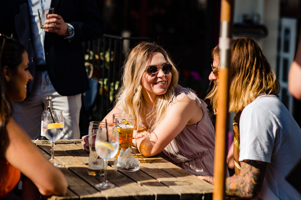 A guest smiling in the sun at The Atlas Pub on Seagrave Road, South West London